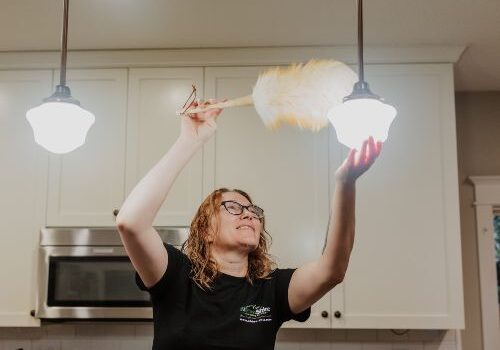 A professional house cleaning technician cleaning a kitchen